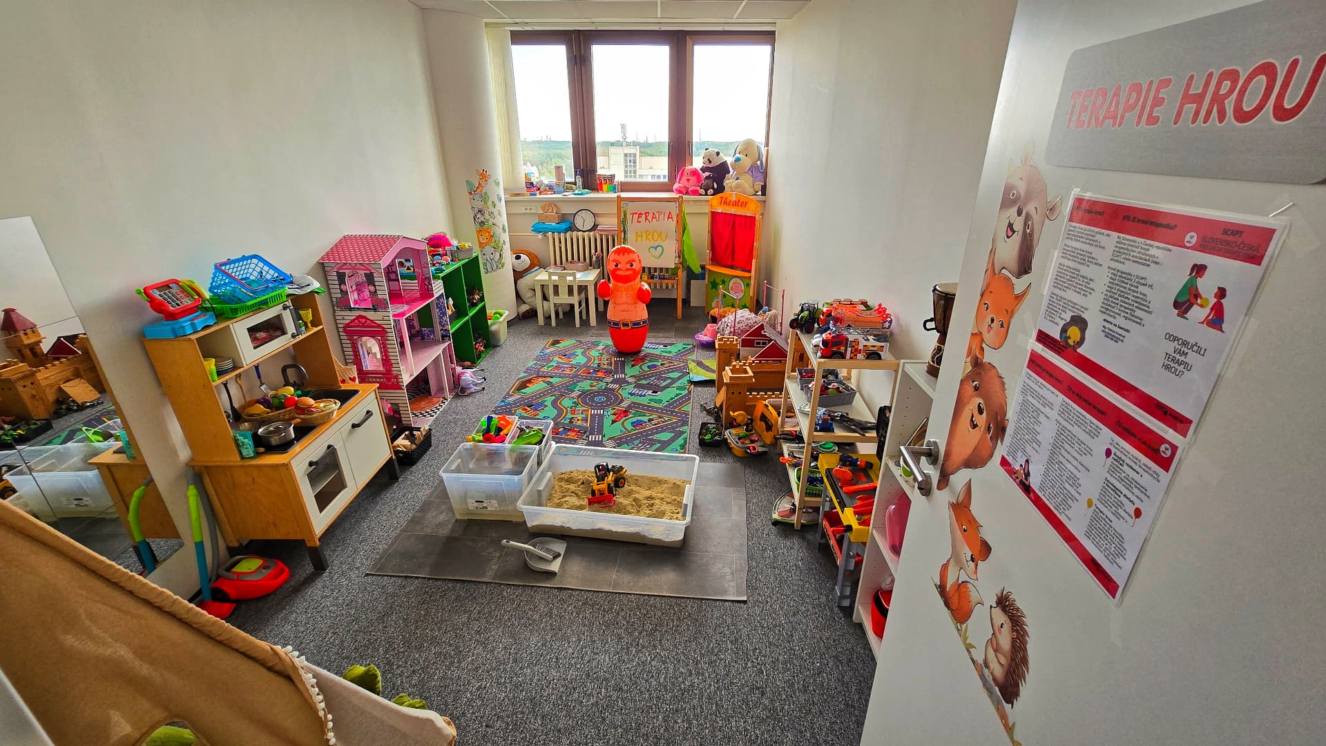 Terapeutická herňa s kuchynkou, domčekom pre bábiky a policami s hračkami